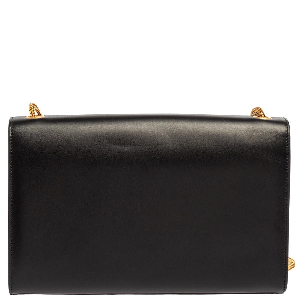 Die Umhängetasche Kate von Saint Laurent hat alle Details:: die sie zu einer besonderen Designertasche machen. Die aus Leder gefertigte Tasche verfügt über eine robuste goldfarbene Schulterkette:: das YSL-Logo mit Quaste auf der vorderen Klappe und