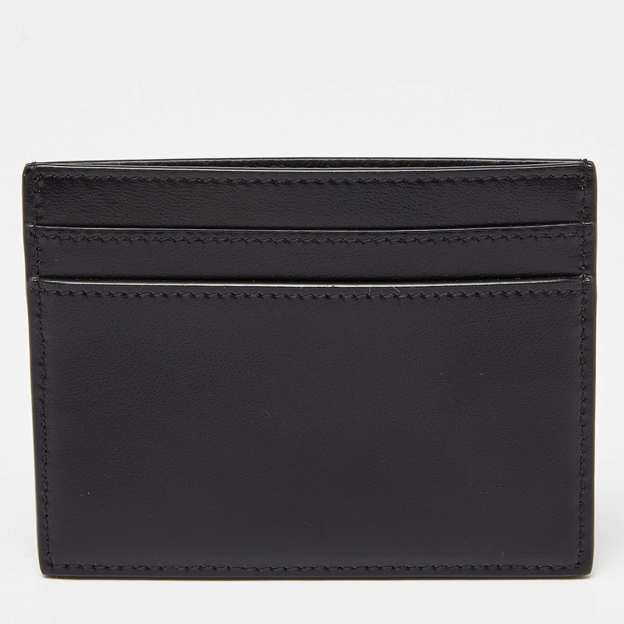 From the house of Saint Laurent, this black card holder made from leather is the perfect accessory to keep your cards in proper order. The smooth leather interior features multiple slots. Adorned with a silver-tone YSL logo at the front, it is truly
