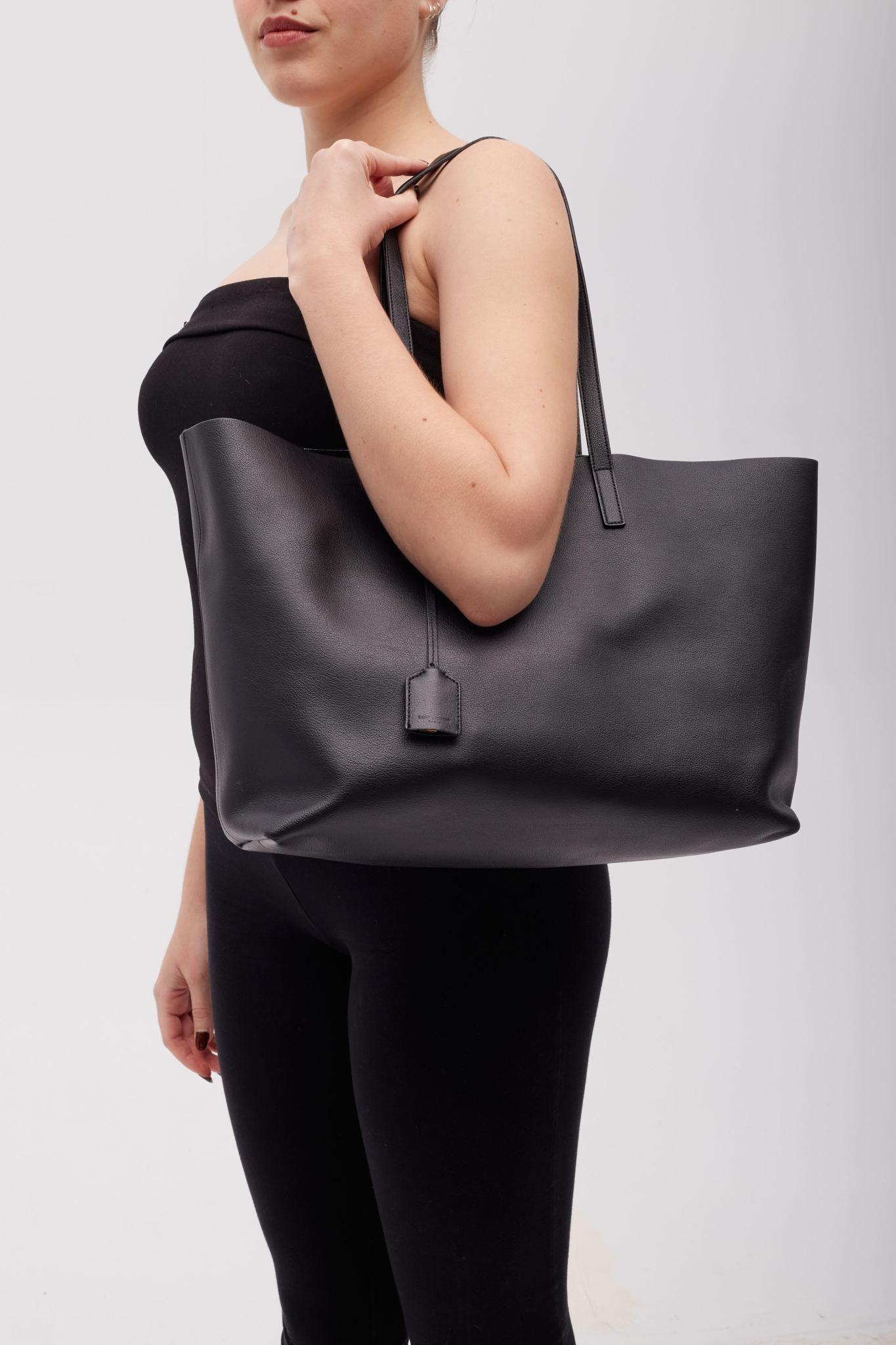 This tote is made with grained calfskin in black. Featuring dual handles at top, sheathed logo charm on detachable lanyard at handle base, gold-tone logo at front, press-stud fastening at top and an interior leather strap with key holder.

Color: