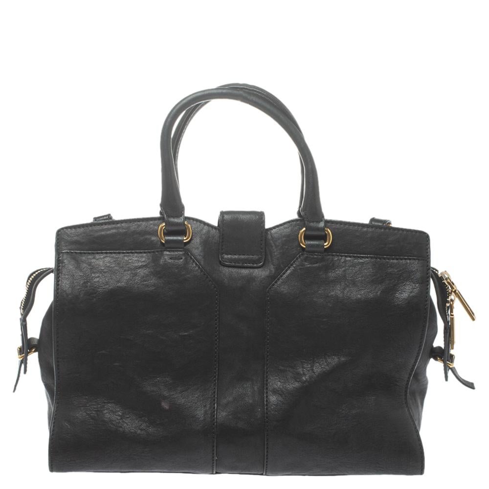 This elegant black Cabas Chyc tote from Saint Laurent is ideal for everyday use. Crafted from leather, the bag is detailed with a gold-tone Y motif snap closure and dual-rolled handles. The top zip closure opens to a spacious interior that is