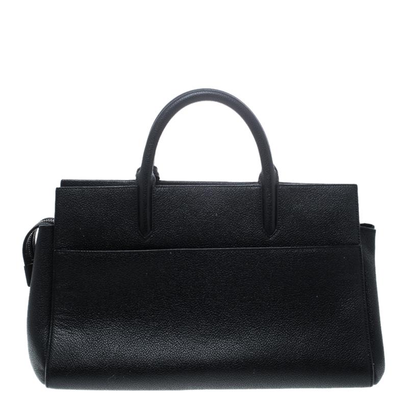 This elegant black Cabas Rive Gauche tote bag from Saint Laurent Paris is ideal for everyday use. Exuding an aura of luxury and elegance, this bag is crafted from leather and is detailed with a leather clochette featuring YSL motif in silver-tone,