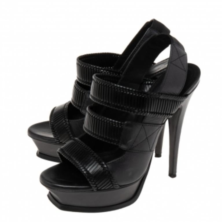 Ces superbes sandales de la Maison Saint Laurent mettront en valeur votre style et vous donneront de l'assurance ! Confectionnées en cuir noir, elles présentent une silhouette à brides avec des semelles compensées, un talon aiguille et un bout