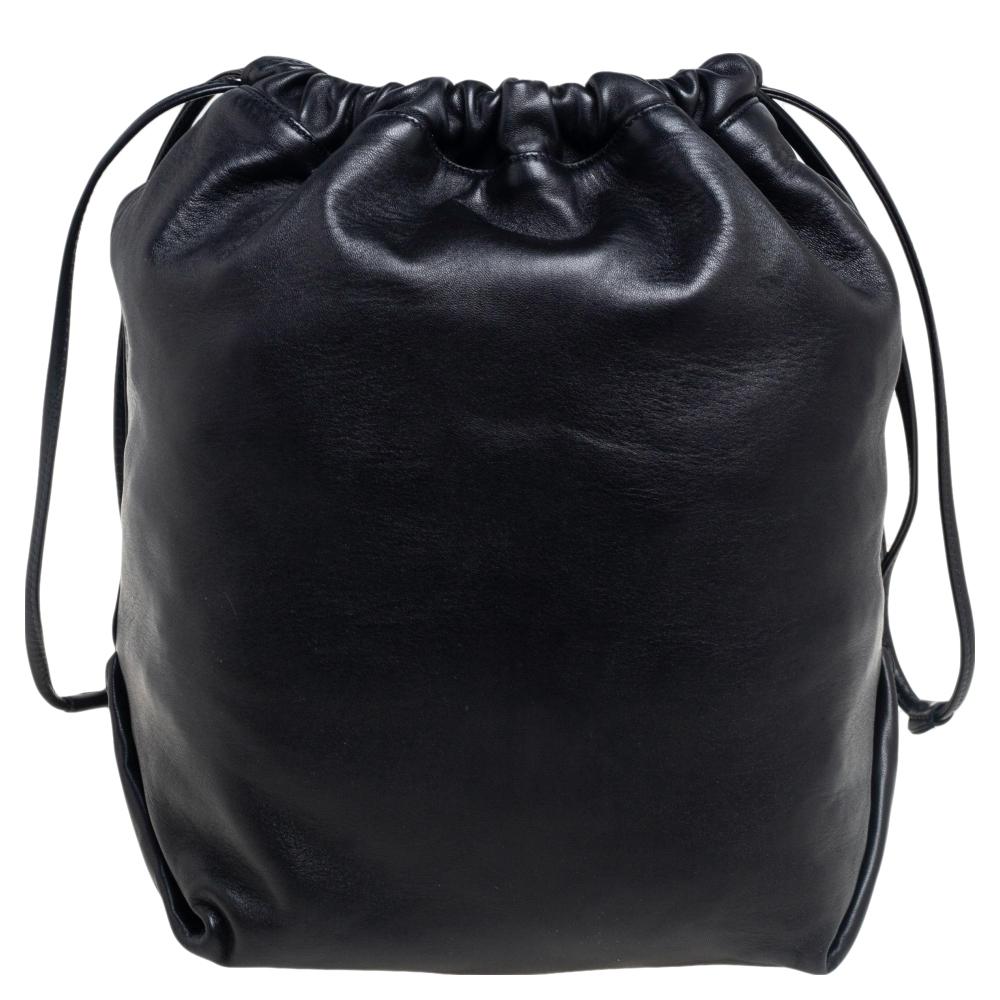 A much-loved bag style, the bucket bag is a closet staple. The Saint Laurent design exhibits a display of minimal details. This bag is crafted from black leather and it has a shoulder strap, brand detail on the front, and an Alcantara