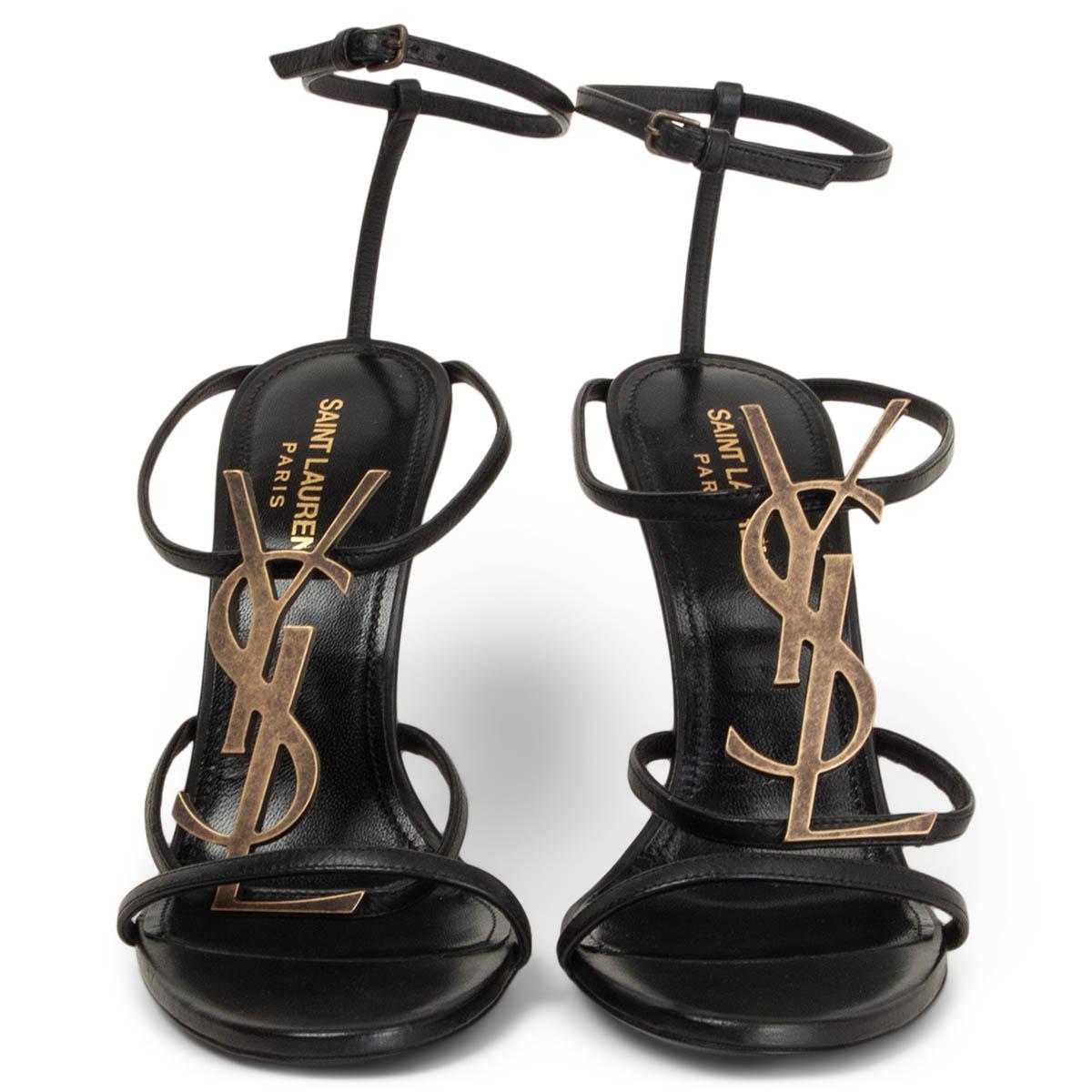 100% authentic Saint Laurent Cassandra YSL logo ankle-strap sandals in black leather and antique gold-tone hardware. Brand new. 

Measurements
Imprinted Size	38
Shoe Size	38
Inside Sole	25cm (9.8in)
Width	8cm (3.1in)
Heel	12cm