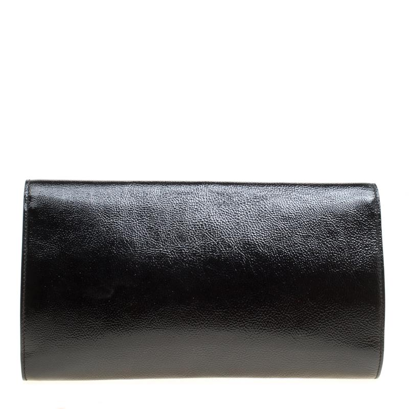 This Belle De Jour clutch from Saint Laurent is your perfect new accessory. The clutch is classy with a modern touch and is crafted from black patent leather. The brand logo is stitched on the fold over flap that opens to a satin lined interior. The