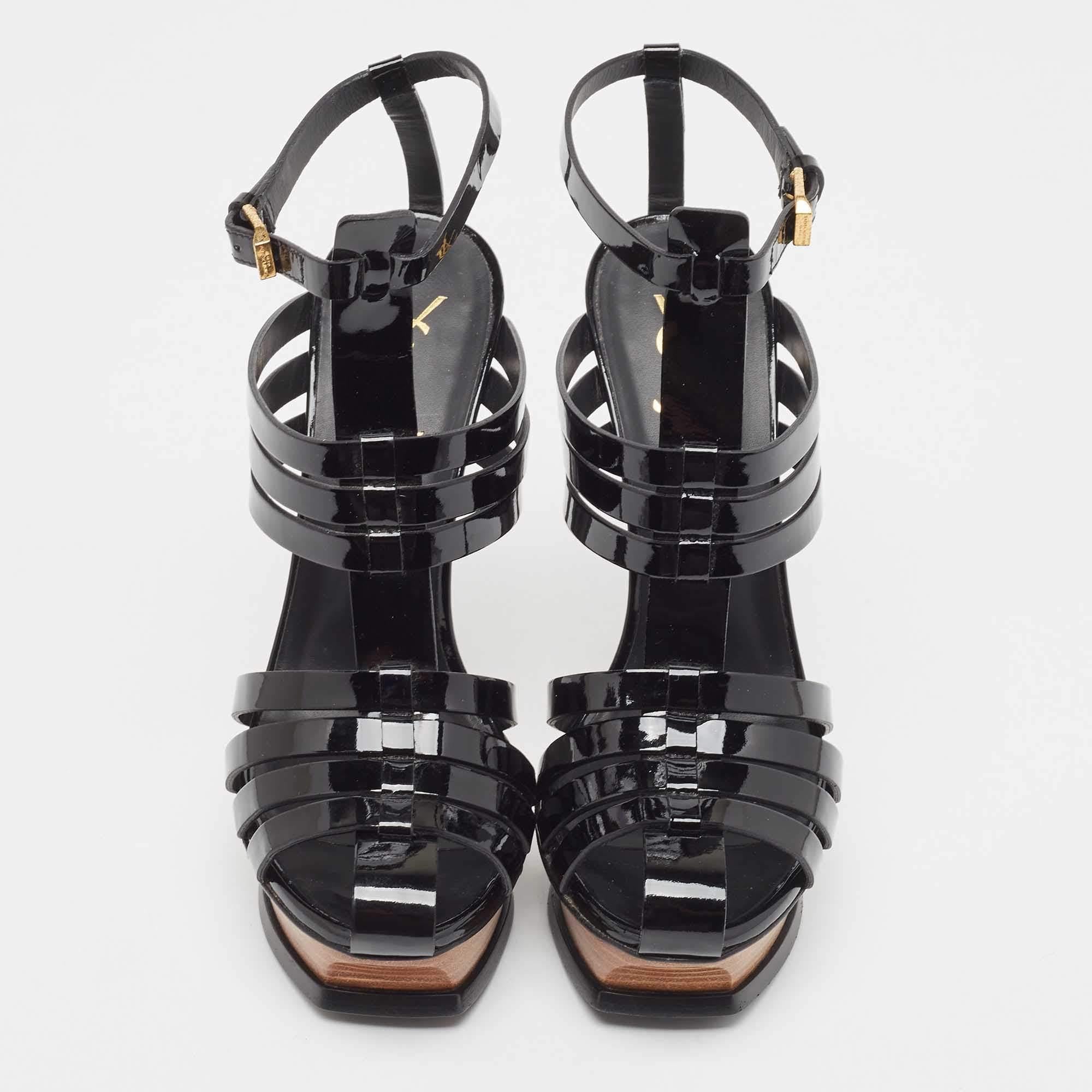 Diese Saint Laurent Sandaletten sind aus Lackleder gefertigt, mit goldfarbener Hardware versehen und auf einem Plateau und 14 cm hohen Absätzen angehoben. Die schwarzen Plateau-Sandalen für Damen sind mit einem Schnallenverschluss an den Knöcheln