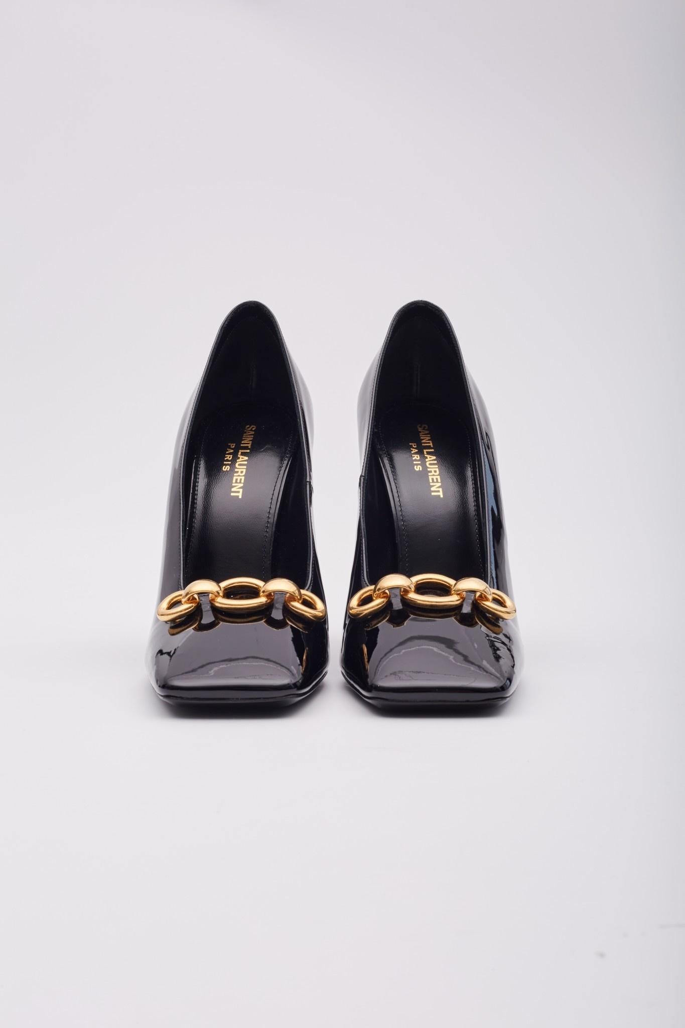 Schwarze Lackpumps von Saint Laurent mit Blockabsatz, quadratischer Zehenform und goldenem Kettendetail am Vorderblatt. Einzelhandel.

Farbe: Glänzendes Schwarz mit goldfarbener Hardware
MATERIAL: Lackleder
Modell Nr. 713924

Größe: EU 40 / US