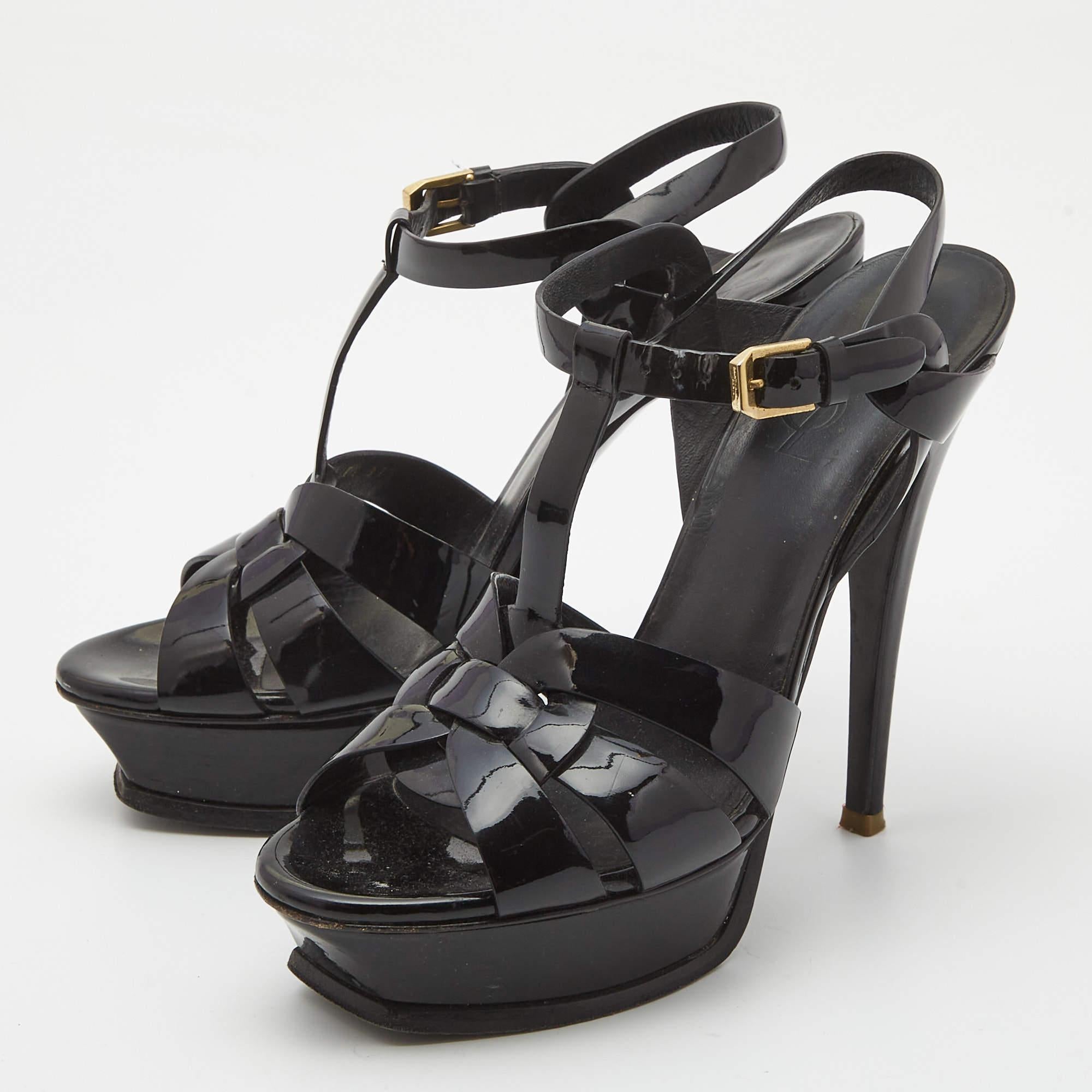 The fashionista in you will instantly fall in love with these Saint Laurent Tribute sandals They are made from patent leather with intertwined straps on the vamps and ankle buckle closure. The gold tone hardware 14m heels and platforms give it a