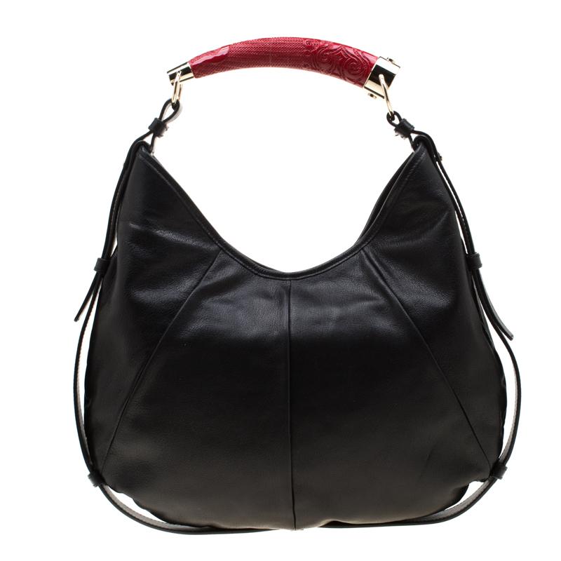 Saint Laurent Paris has infused interesting, unique details in this notable Mombasa hobo. It is made of black leather with protective leather trim outlining the bag and tassel detail at the front. A signature of the Mombasa style, the bag has a horn
