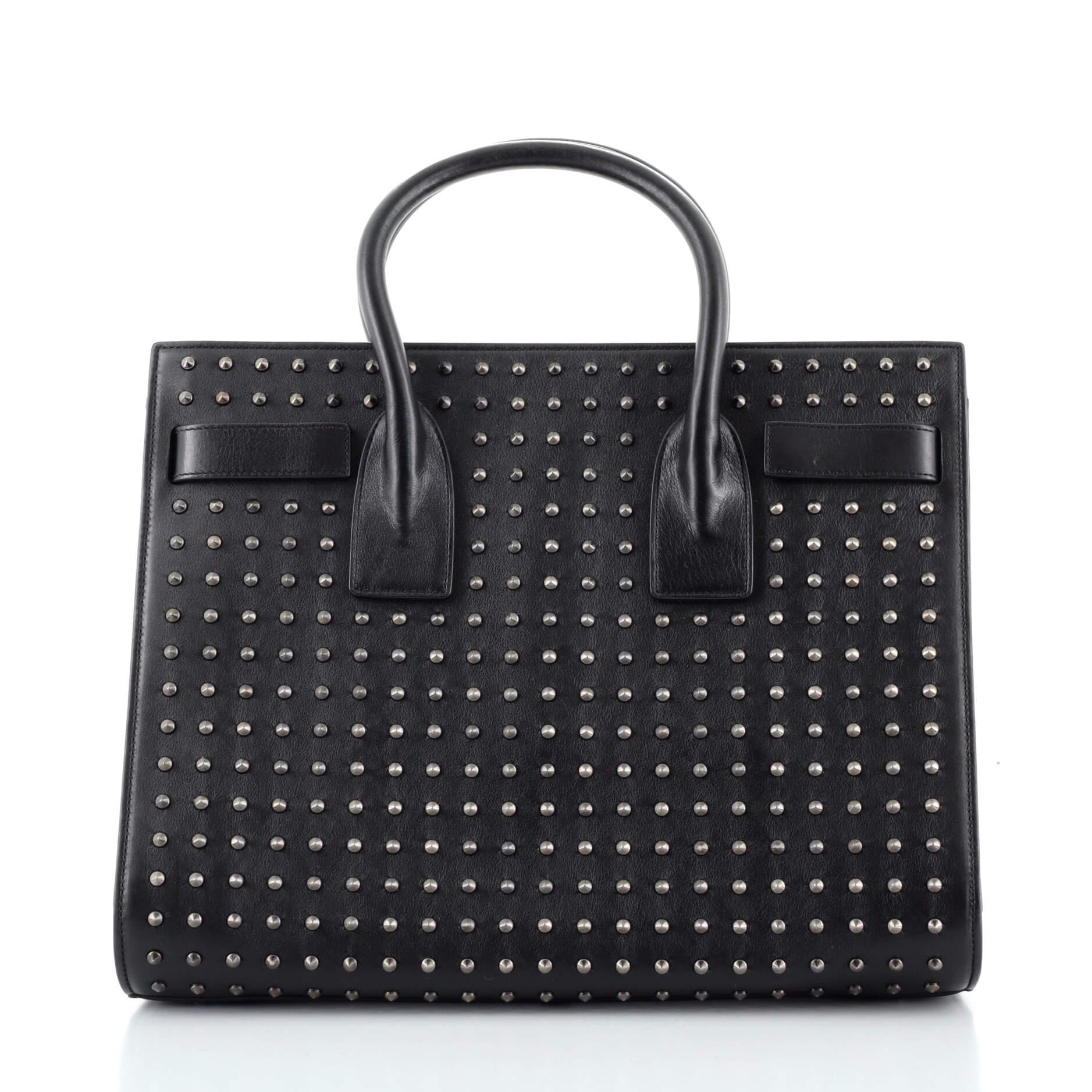 Saint Laurent Schwarze beschlagene Ledertasche Sac de Jour klein

Zustand Details: Starker Geruch im Innenraum. Falten an der Außenseite und an den Griffen, Einkerbungen und Schrammen am Sockel, Abnutzung im Inneren, Kratzer und Verfärbungen an den