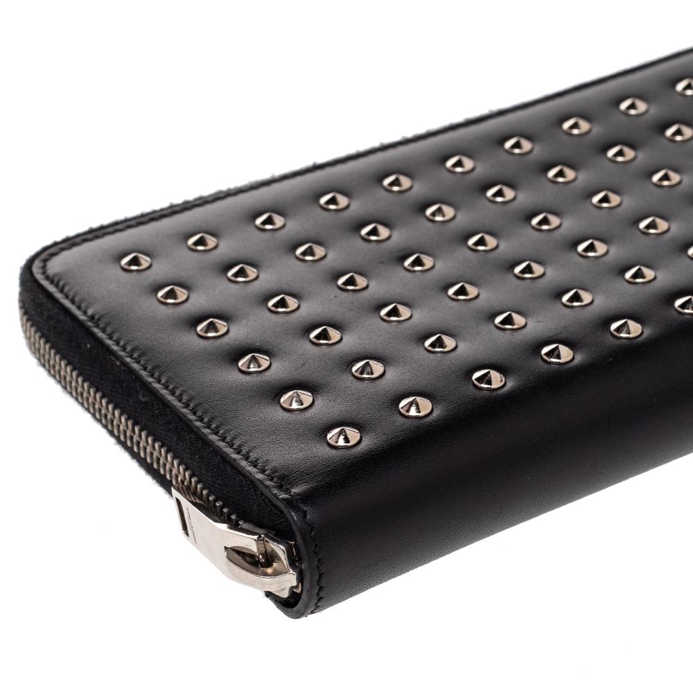 Sewn beautifully using leather, this Saint Laurent wallet stands for resistance and durability. Decorated with studs on the front, the wallet features a well-equipped interior and silver-tone hardware. It is surely going to accompany your days with