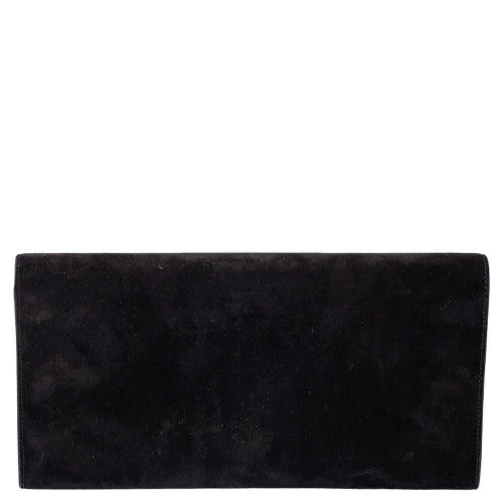This exquisite Cassandre clutch from Saint Laurent is a chic accessory that represents the brand's rich aesthetics and elegant designs. Crafted from black-hued suede, this easy-to-carry clutch has a flap style with the YSL logo in gold-tone with a