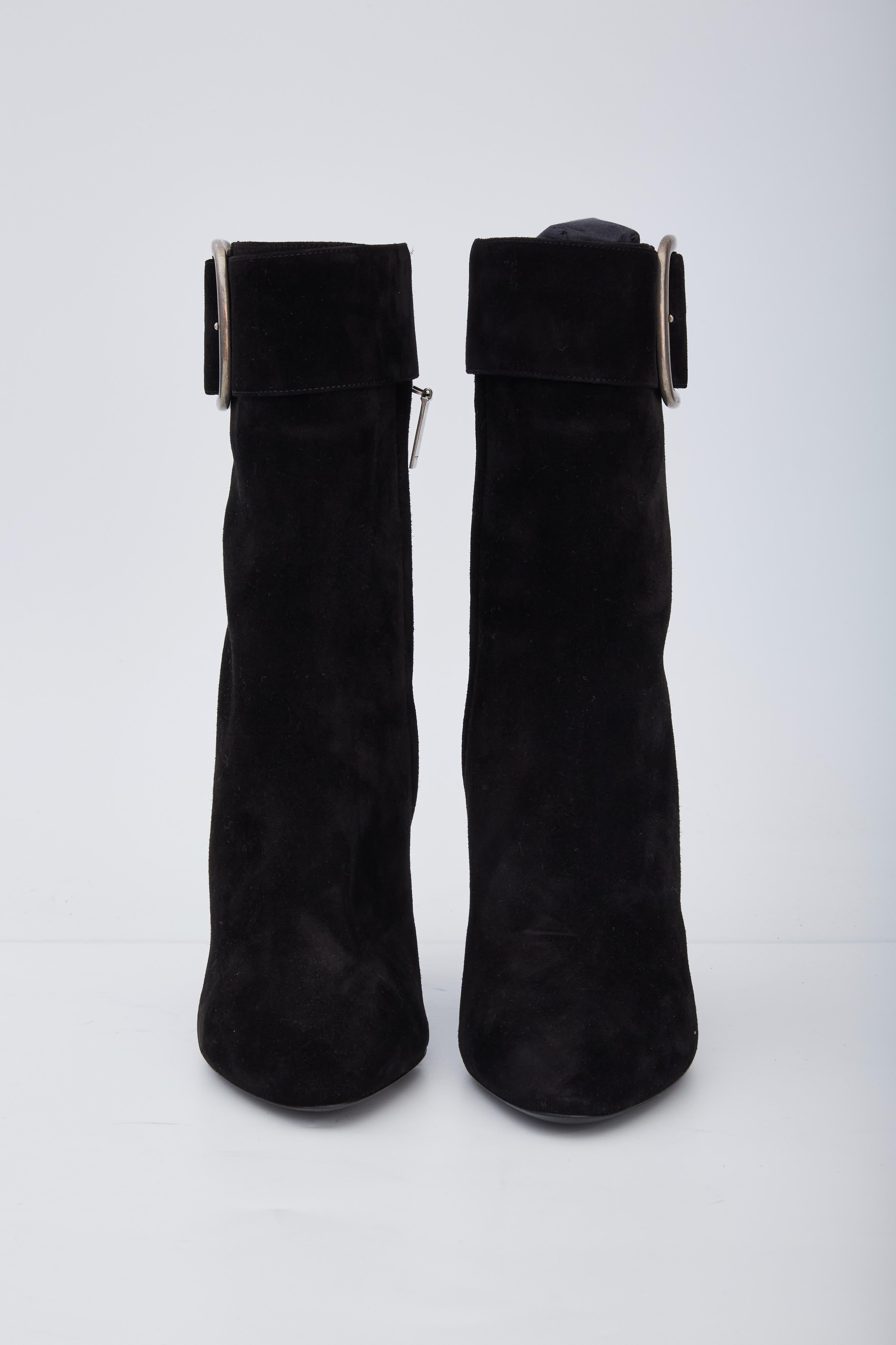 These boots are made of Joplin calfskin suede leather in black. The boots feature a wrap-around leather strap with an aged silver buckle, a pointed toe, and a 4-inch block heel.

COLOR: Black
MATERIAL: Suede
ITEM CODE: 529331
SIZE: 39 EU / 8 US
HEEL
