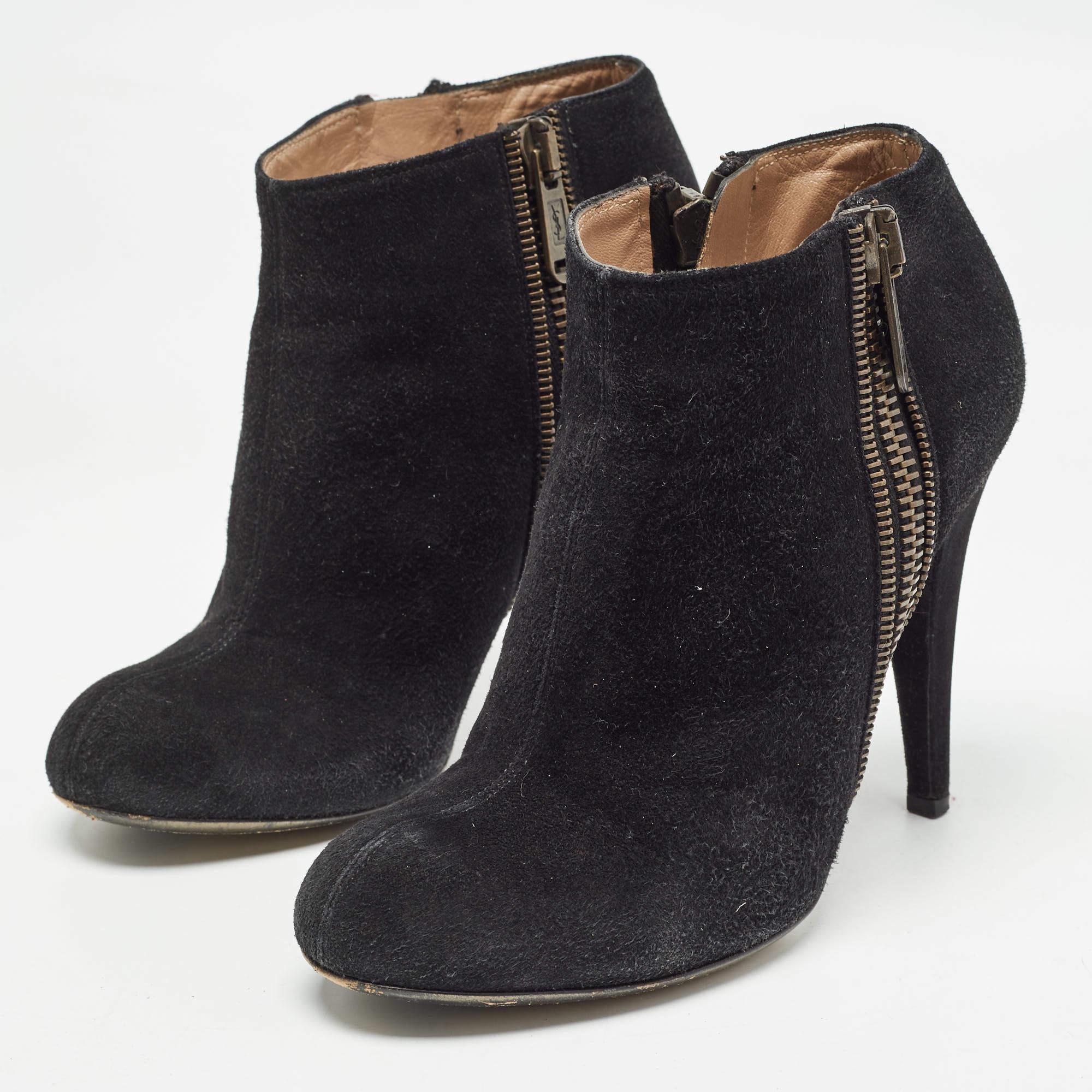 Cette paire de bottines Saint Laurent apporte une touche de mode. Fabriquées en daim, elles arborent un extérieur élégant dans un noir élégant. Des fermetures éclair latérales et des talons de 11 cm les complètent.