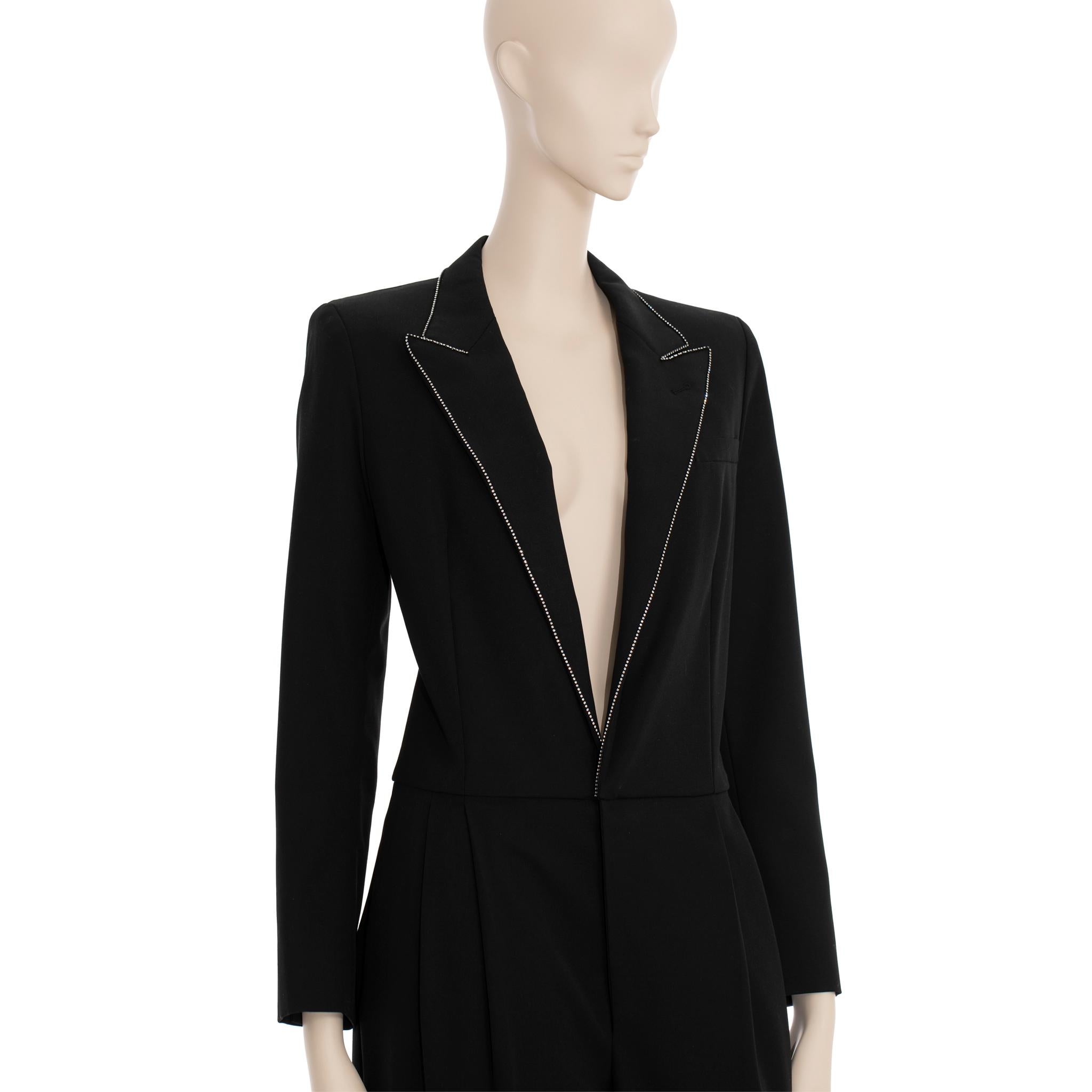 This Saint Laurent jumpsuit offers a stylish and sophisticated look that is perfect for formal events. Cut in a tuxedo style, this jumpsuit is adorned with crystal detailing on the chest and cuffs for an added glamorous touch. Available in a French