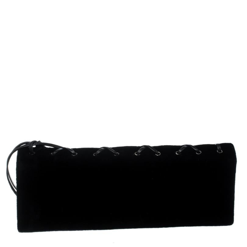 You'll never go unnoticed when you step out carrying this amazing clutch from Saint Laurent. The black clutch is crafted from velevet and features a crisscross lace up detailng. The front flap closure opens to a satin-lined spacious interior. Pair