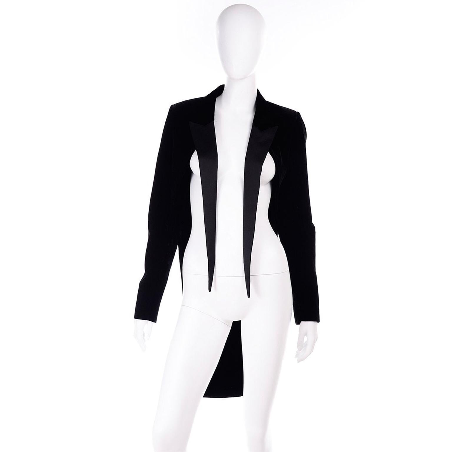This is a fabulous contemporary Saint Laurent black velvet and satin tuxedo style cutaway jacket. This jacket features tails and flyaway satin peaked lapels, which form the main detail of the front. This open front jacket has long sleeves and a back