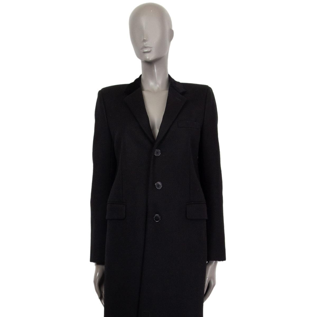 Cappotto monopetto Saint Laurent in misto lana nera (manca l'etichetta) e dettaglio del collo in velluto nero. Si chiude con bottoni sul davanti e presenta tasche con patta e uno spacco sul retro. Foderato in tessuto nero. È stato indossato ed è in