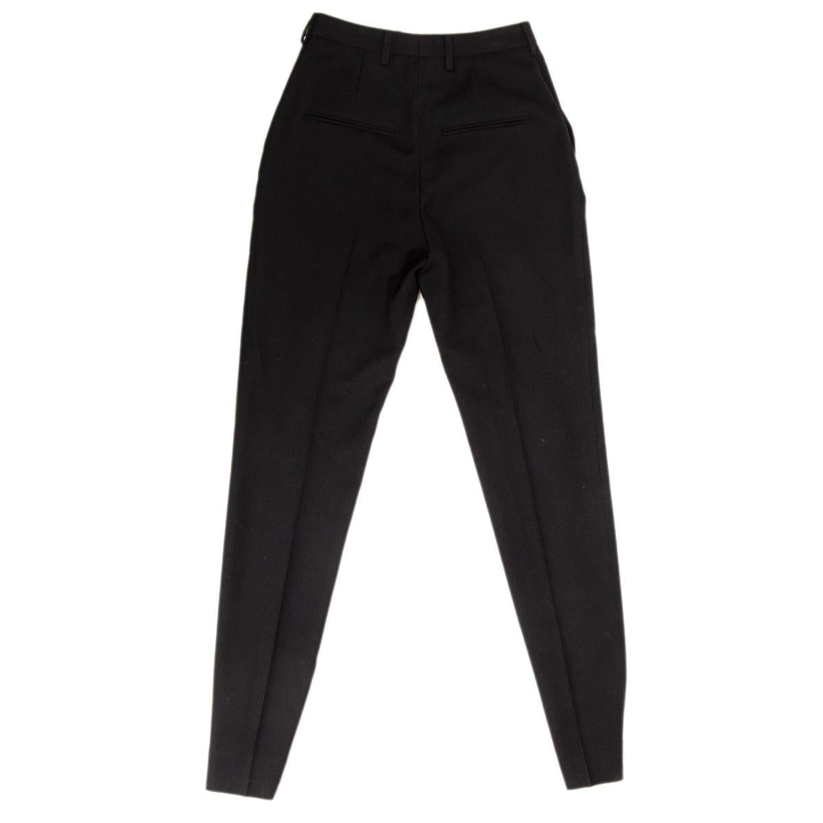 pantalon classique Saint Laurent 100% authentique en laine noire (100%) avec une jambe étroite et des plis devant et derrière. Il a des passants de ceinture, des poches à l'avant. Se ferme avec un crochet et un bouton dissimulés à la taille et une