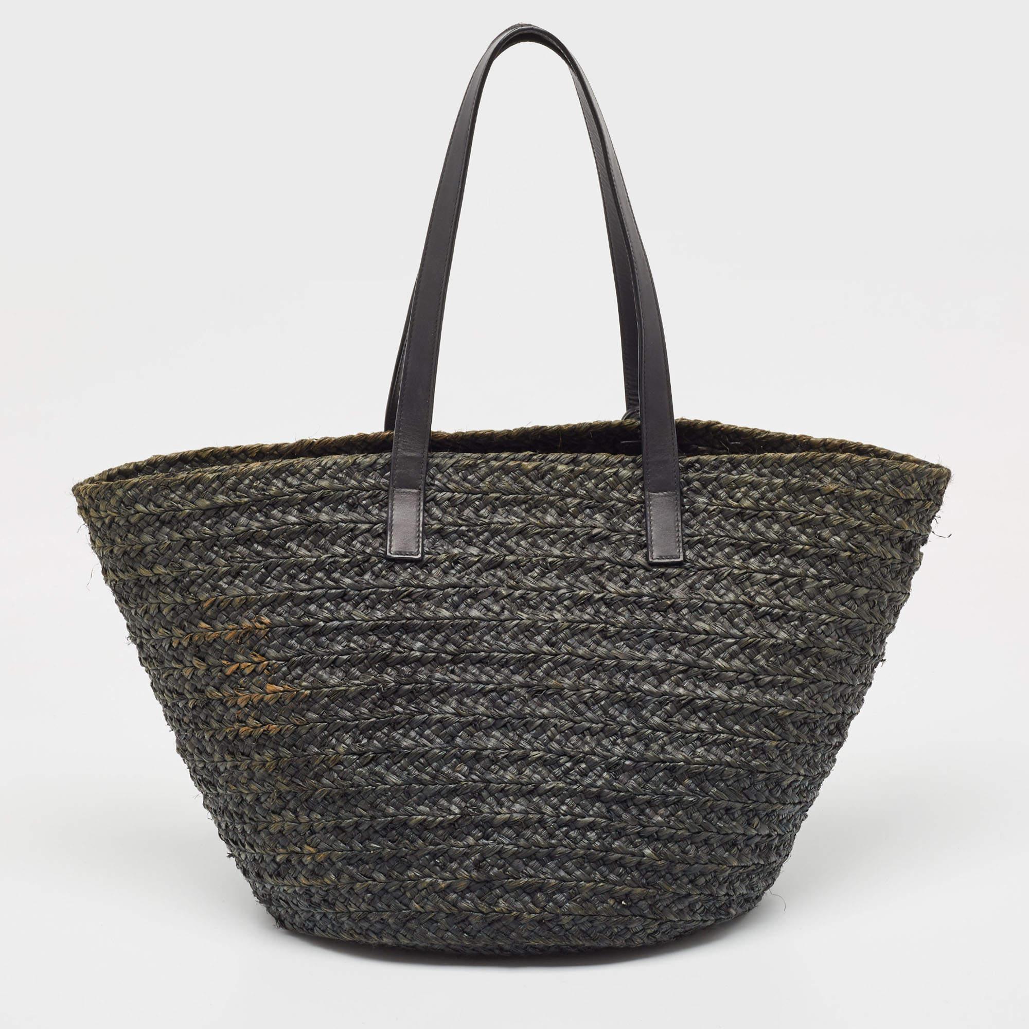 Crafted by Saint Laurent, this exquisite basket bag epitomizes elegance and craftsmanship. The fusion of black woven raffia and supple leather exudes sophistication. Its spacious interior and structured silhouette make it both functional and