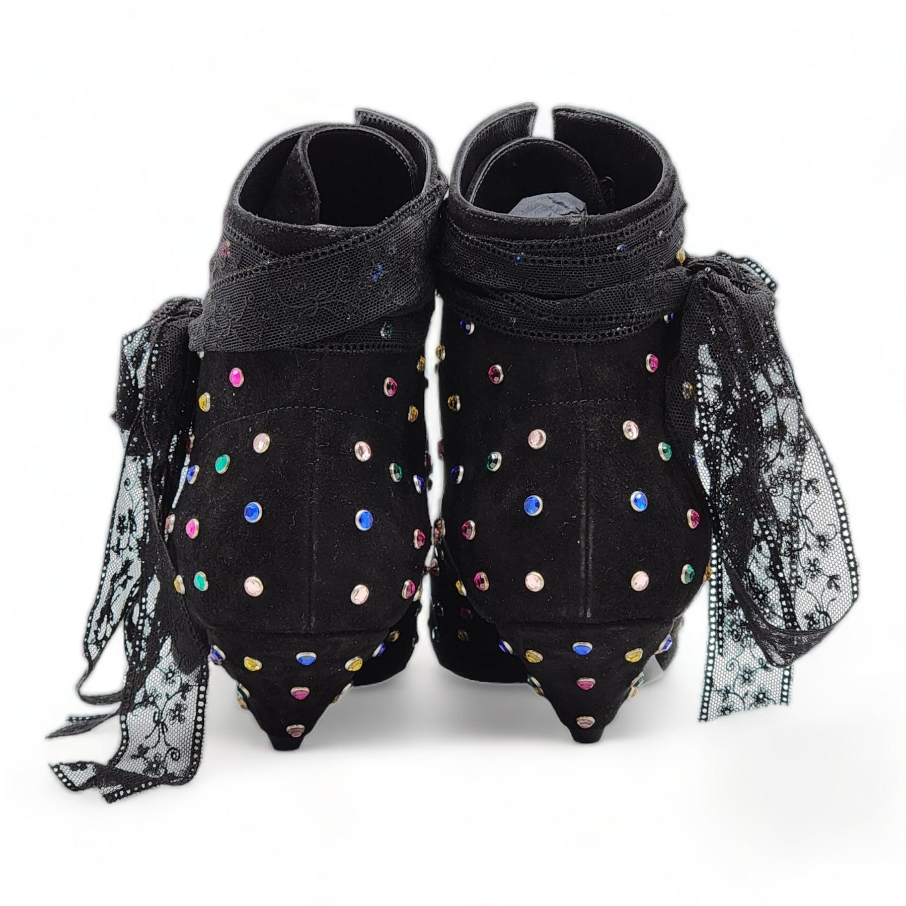Stivali alti alla caviglia in camoscio nero di Saint Laurent. A punta. Ricoperte di borchie di cristallo multicolore, legate con nastri di pizzo nero, sollevate su un tacco triangolare. Finitura in pelle scamosciata. Suola in pelle tono su tono.