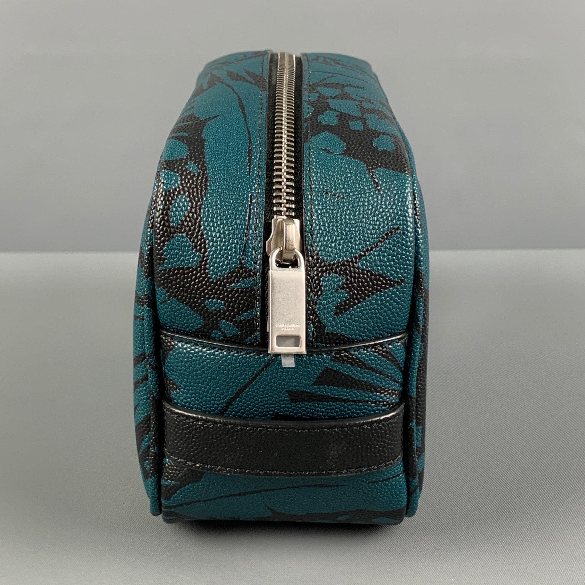 SAINT LAURENT toiletry bag comes in a teal & black leaf print canvas material featuring a top zipper closure. Made in Italy. Excellent
Pre-Owned Condition. 

Marked:   GUE650125-0621 

Measurements: 
  Length: 8 inches  Width: 3.25 inches 