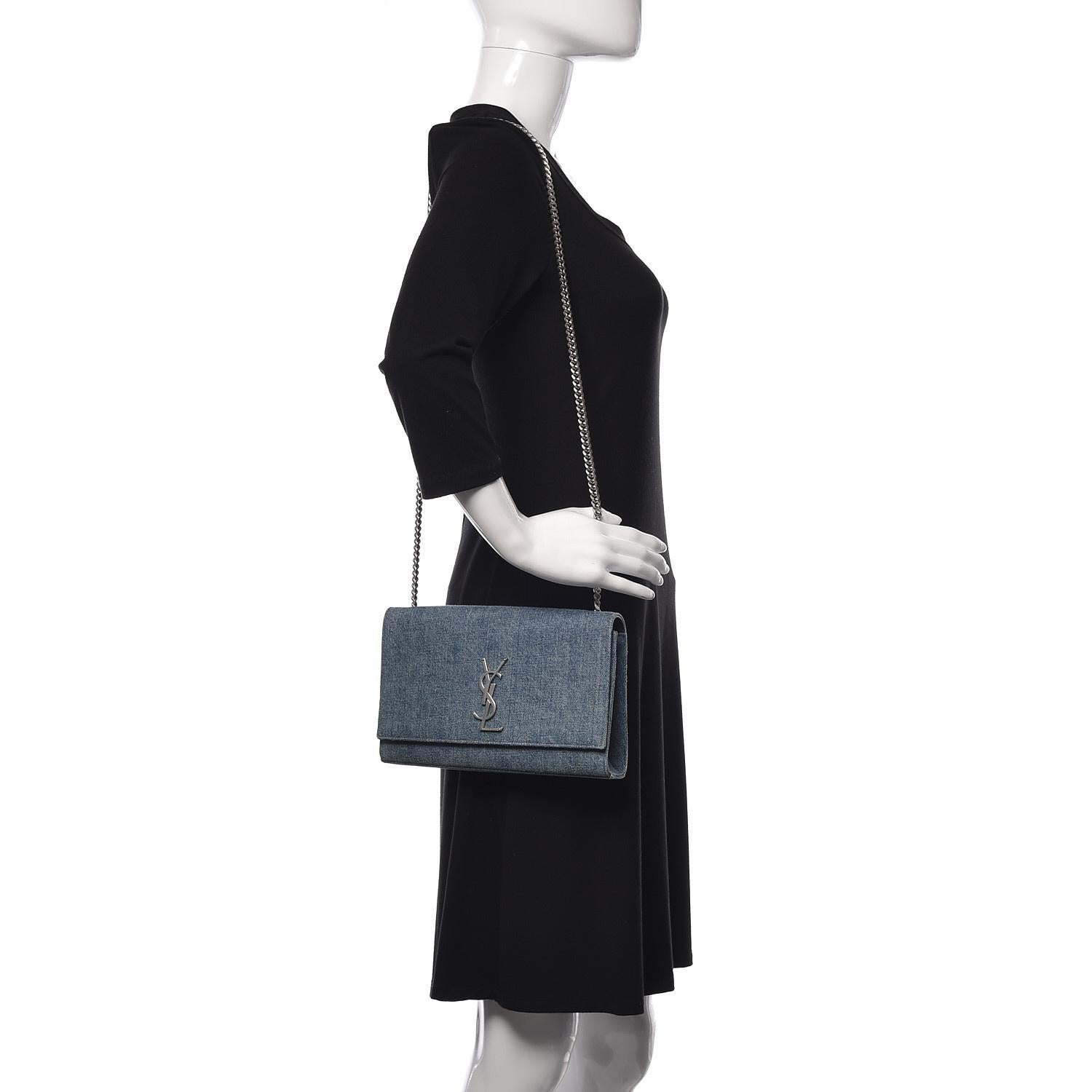 SAINT LAURENT BLUE DENIM MONOGRAM KATE WOC BAG

This Saint Laurent bag is constructed of blue denim with a silver-tone YSL monogram logo at the front. Designed with a structured silhouette, it features a silver-tone chain shoulder strap and a