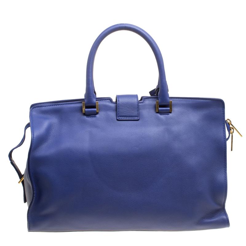 This elegant blue Cabas Chyc tote bag from Saint Laurent Paris is ideal for everyday use. Crafted from leather, the bag is detailed with a gold-tone Y motif snap closure, dual rolled handles and protective metal feet at the bottom. The top zip
