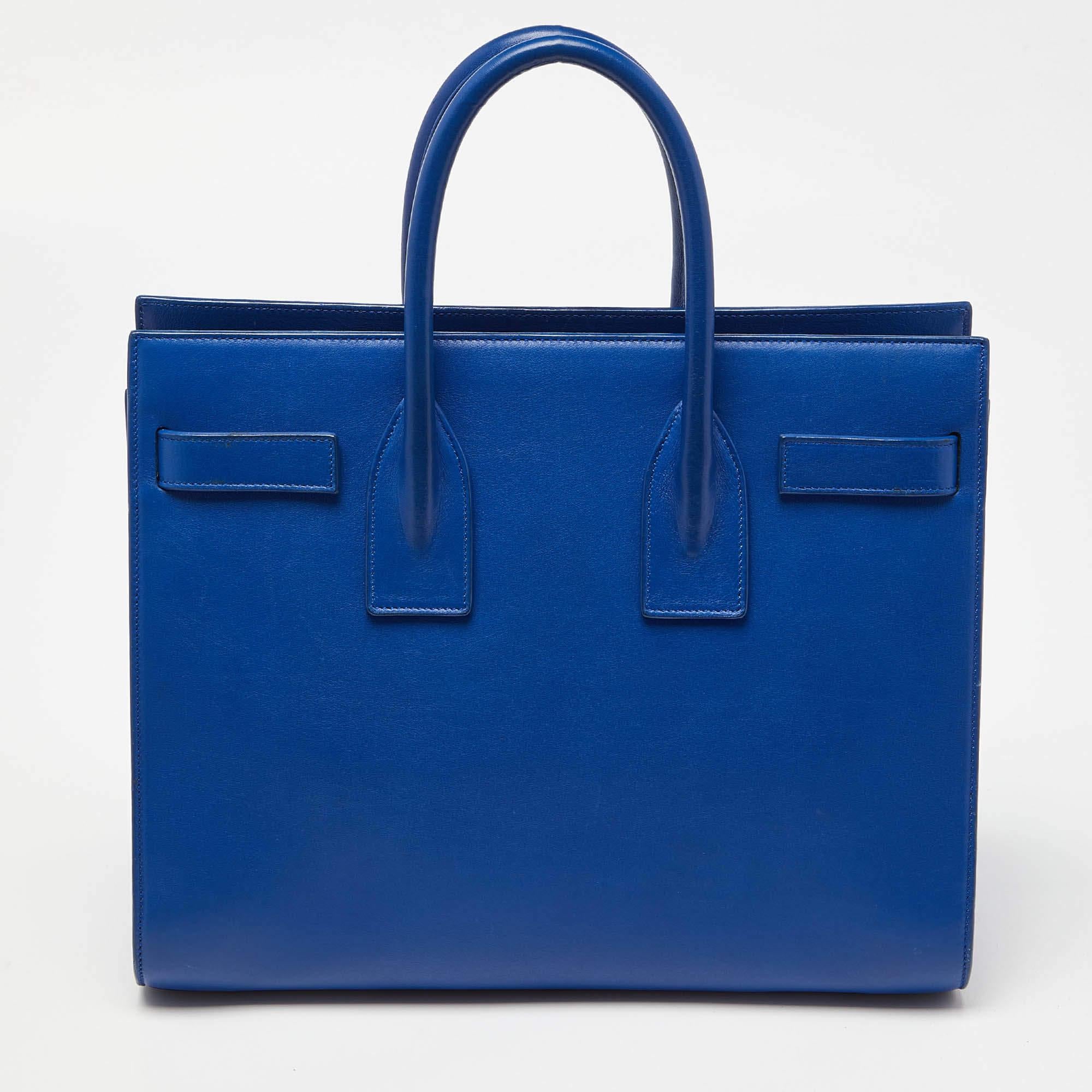 Mit dieser Tasche aus dem Hause Saint Laurent, die eine wunderbare Balance zwischen Wesentlichkeit und Opulenz schafft, sind Ihre Bedürfnisse an Handtaschen erfüllt. Er ist mit praktischen Funktionen ausgestattet, die den Alltag