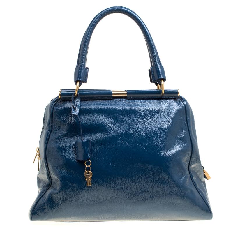 You can surely count on this lovely Majorelle satchel by Saint Laurent Paris for an all-time statement look. Crafted from patent leather, it features a sleek structured design with two metal frame rods on the top. It features a YSL luggage tag, a