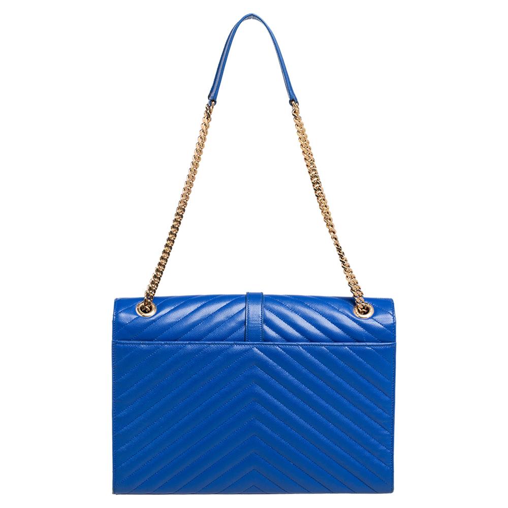 Fashioned using blue chevron-quilted leather into a structured silhouette, this Saint Laurent shoulder bag has high style and a timeless charm. It has a flap design and the front is highlighted with a gold-tone YSL logo. The interior is lined with