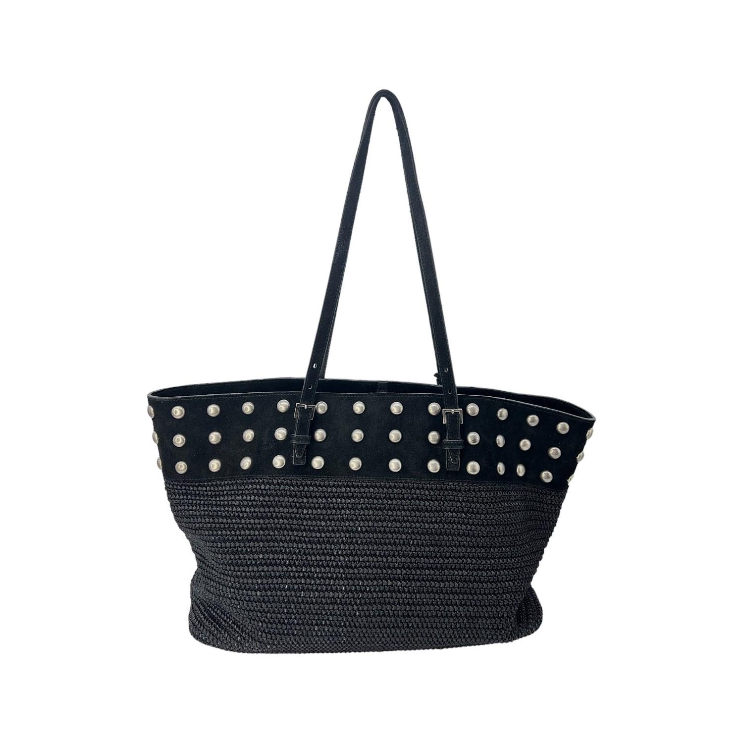 This Saint Laurent Boucle Studded Raffia Shopping Tote is finely crafted of a black suede, leather, and raffia fabric exterior with silver-tone hardware studs. It has dual flat shoulder straps. It has a buckle closure that opens up to a black fabric