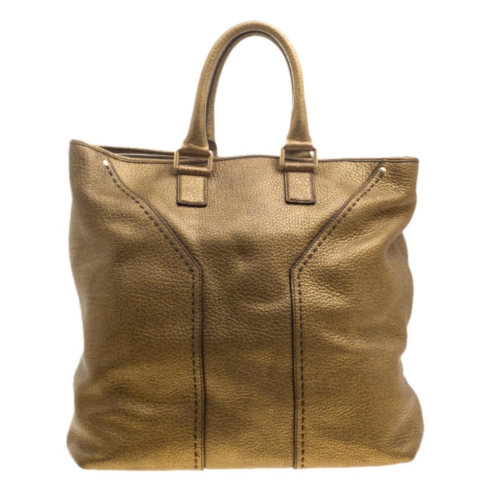 Complete your look with this creation from Saint Laurent. The tote flaunts a metallic hue and serves the function of spacious storage with its roomy canvas interior having a zip divider. The exterior is crafted with pebbled leather. It is complete
