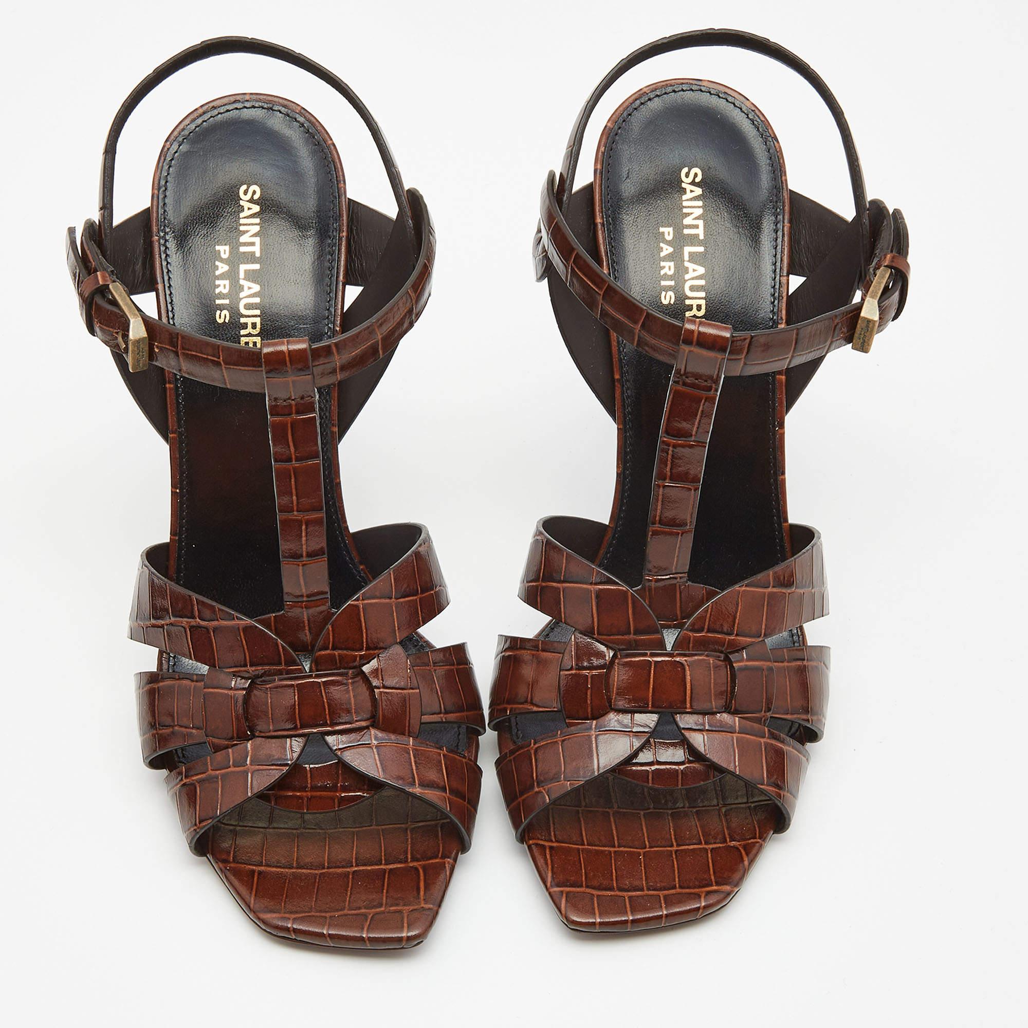 A timeless aesthetic and stellar craftsmanship in shoemaking are evident in these Saint Laurent platform sandals. From their interwoven construction using croc-embossed leather to the sturdy heel, these brown-hued Tribute sandals can be styled with