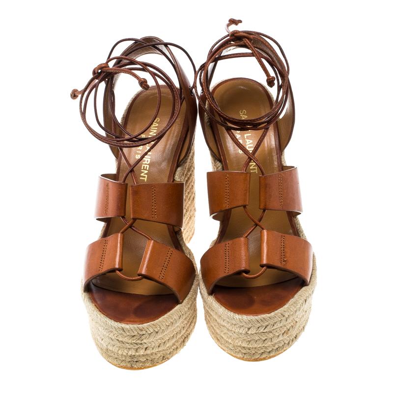 These lovely Saint Laurent sandals will bring you the right amount of style and shine. They are crafted from brown leather and feature an open toe silhouette. They flaunt lace-ups on the vamps and come equipped with ankle fastenings, comfortable