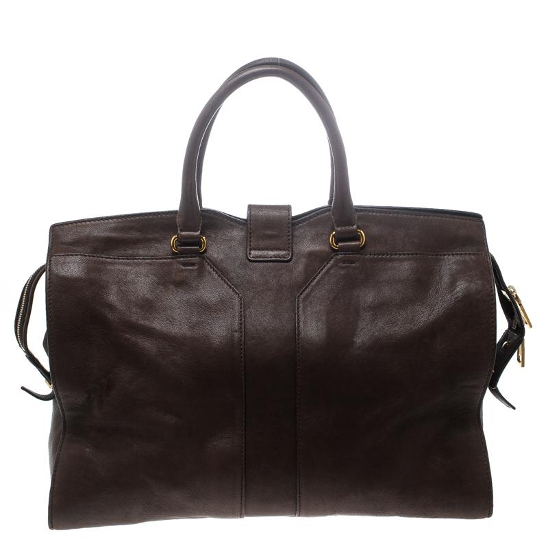 This elegant brown Cabas Chyc tote from Saint Laurent is ideal for everyday use. Crafted from leather, the bag is detailed with a gold-tone Y motif, dual rolled handles and metal feet. The top zip closure opens to a spacious fabric interior that is