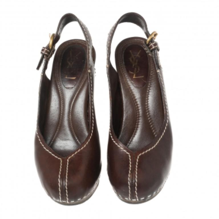 These sandals from the House of Saint Laurent are absolutely stunning. They have been crafted from brown leather and adorned with rounded-toes, platforms, and a slingback. For a classy touch, they are embellished with gold-tone fittings and elevated
