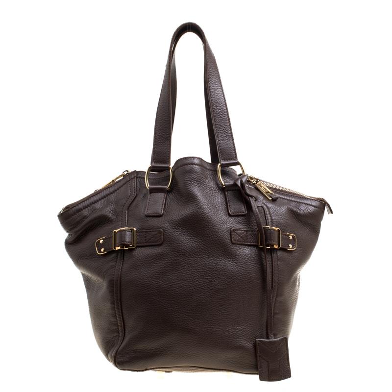 A loved style, the Downtown tote from Saint Laurent Paris is a stylish and spacious bag that you can carry all day long. It is crafted with leather. The exterior of this tote is adorned with a subtle brown hue and is accented with buckled straps on