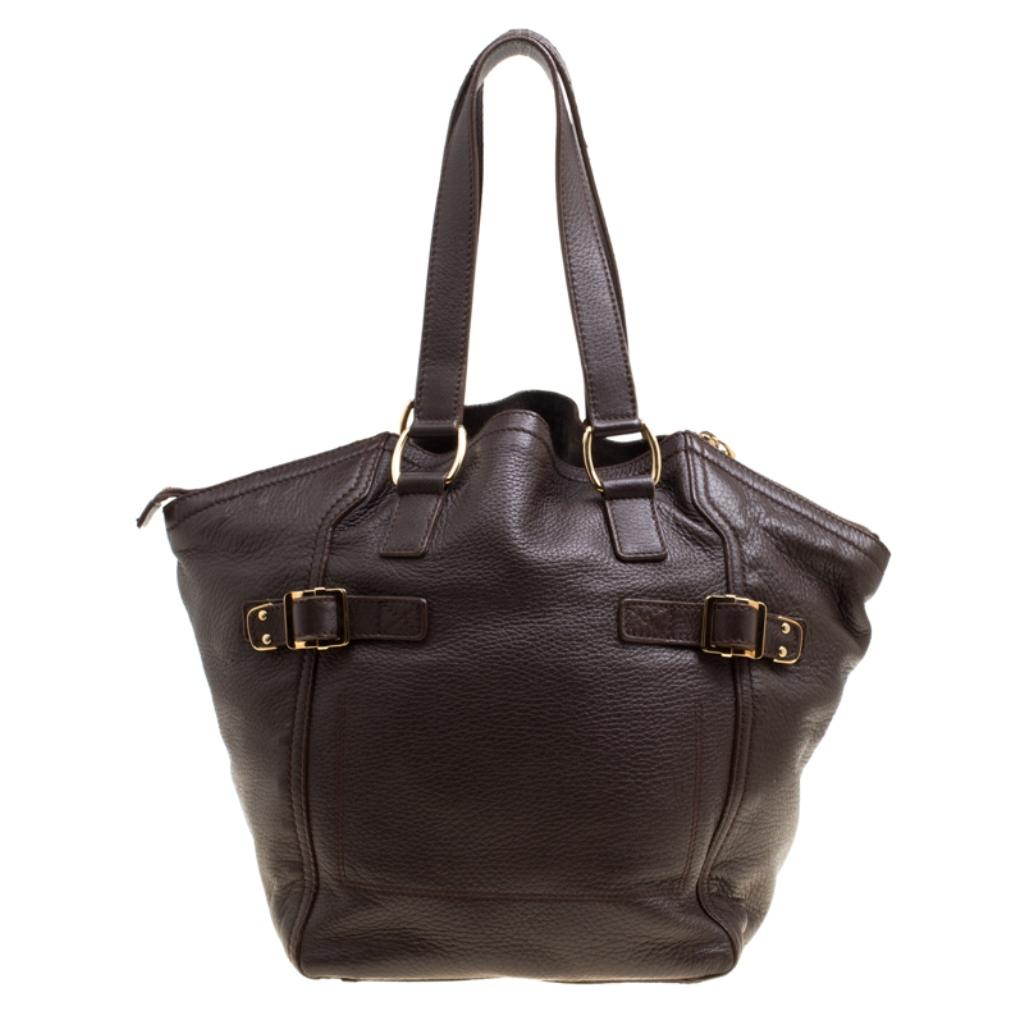 A loved style, the Downtown tote from Saint Laurent Paris is a stylish and spacious bag that you can carry all day long. It is crafted with leather. The exterior of this tote is adorned with a subtle brown hue and is accented with buckled straps on