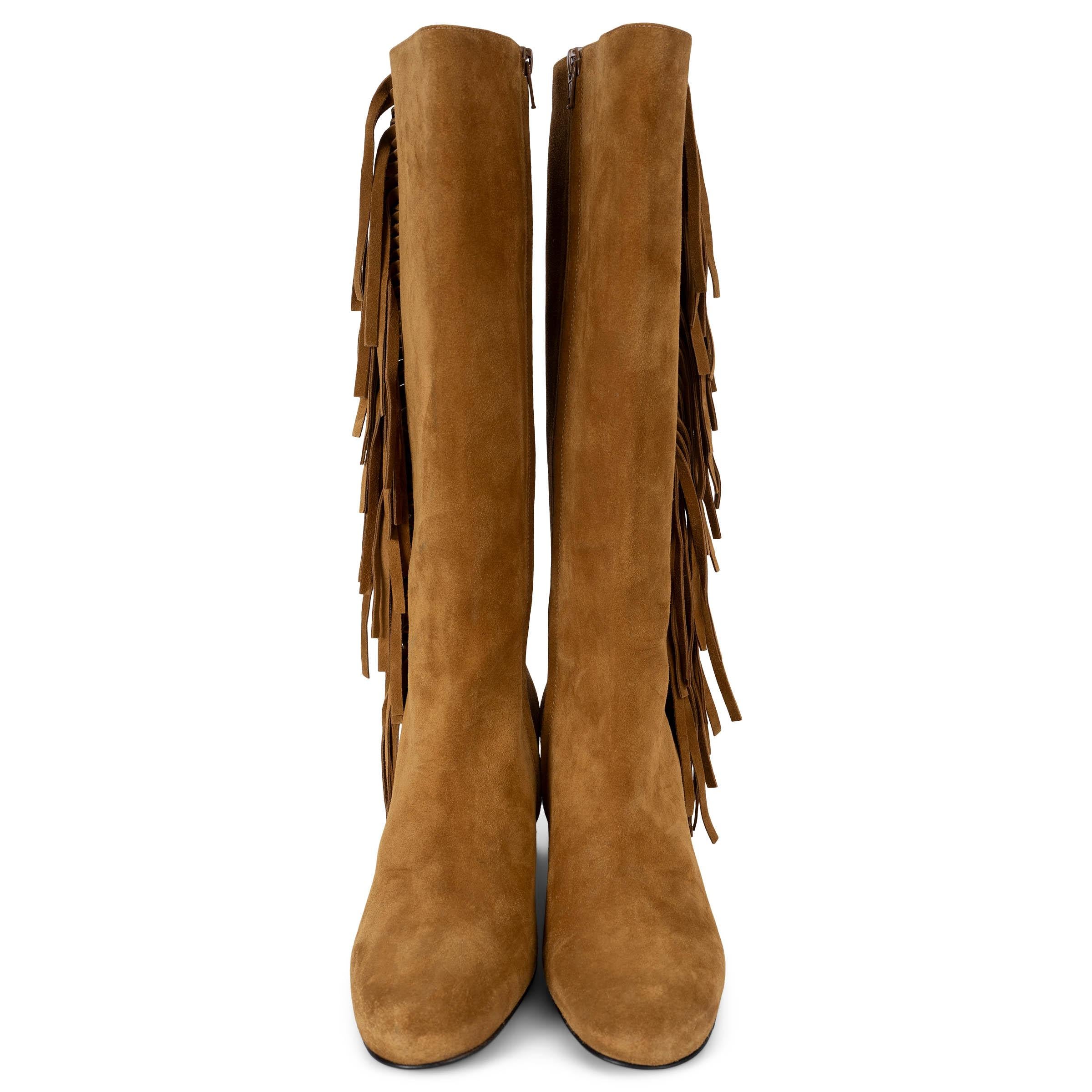 These 100% authentic Saint Laurent Babies boots in tan suede feature a stylish fringe trim on the side, adding a bohemian touch to their design. They have suede-covered block heels and rounded toes for a chic, comfortable fit. The boots open with a