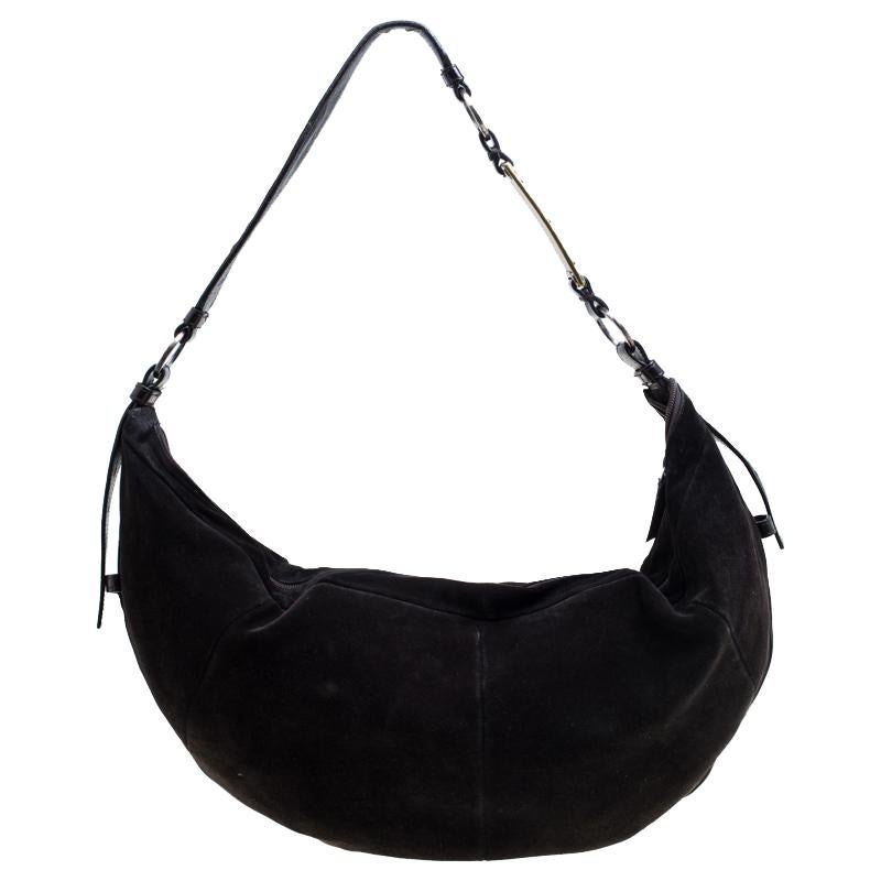 This Saint Laurent Paris bag is splendid for everyday use as well as for special events. A versatile accessory, it's made from suede and comes with a fabric lined interior that is secured by a zip closure. A single handle completes this hobo.

