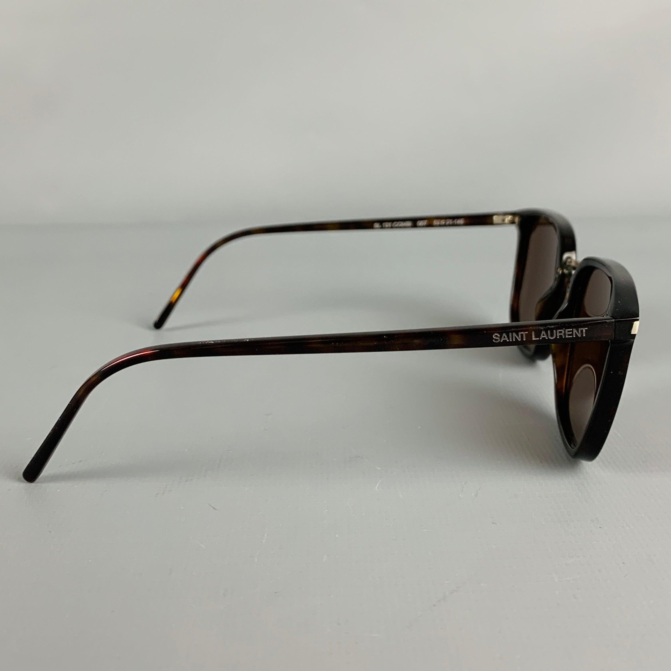 SAINT LAURENT sunglasses
in a brown acetate featuring tortoiseshell pattern, and tinted lenses. Includes case. Made in Italy.Excellent Pre-Owned Condition. 

Marked:   SL 131 COMBI 007 52 21-145 

Measurements: 
  Frame Width: 14 cm.Frame Height: