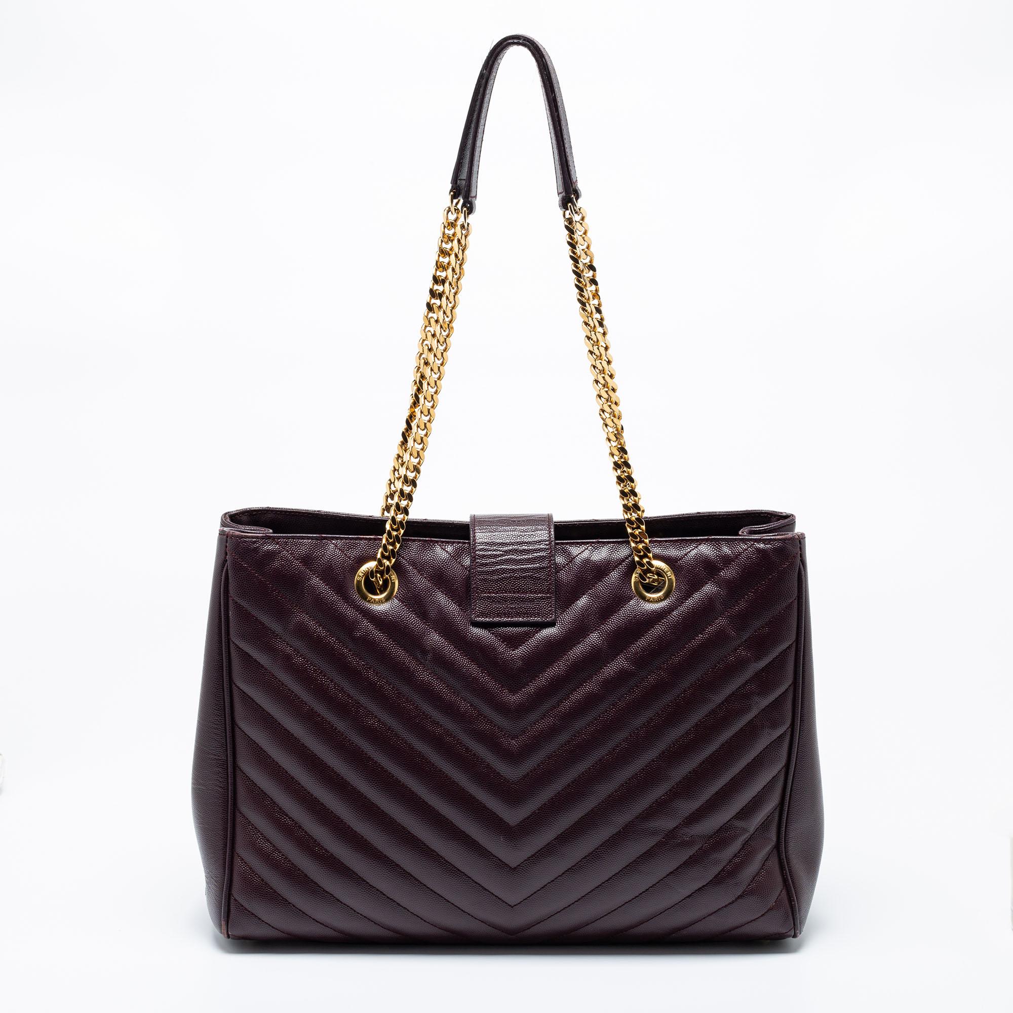 This mesmerizing burgundy tote from Saint Laurent has been meticulously crafted from leather in a chevron-quilted pattern and is designed with gold-tone hardware and a YSL logo detail on the front flap. The sensuous bag opens to a fabric-lined
