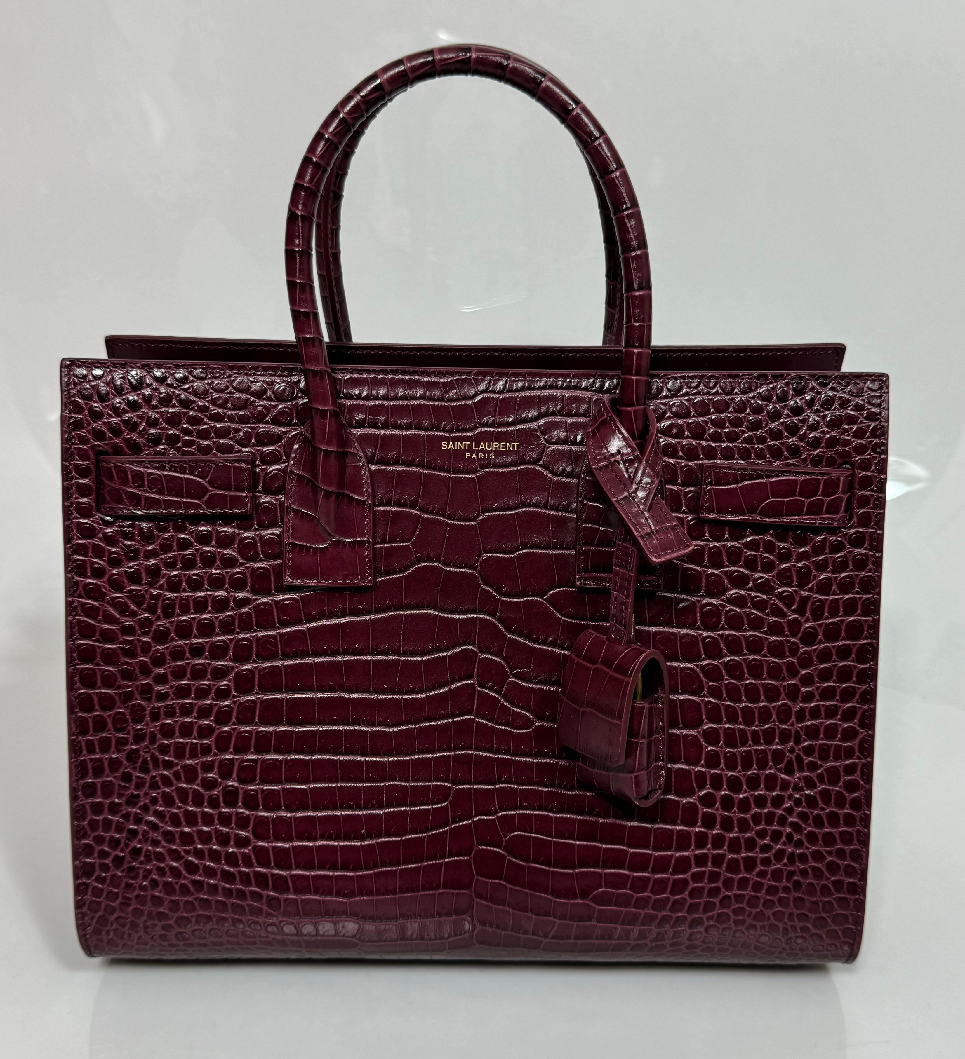 Saint Laurent Burgunderfarbenes, Krokodilleder geprägtes Baby Sac de Jour - Neu, nie geschnitzt
Apt übersetzt als 