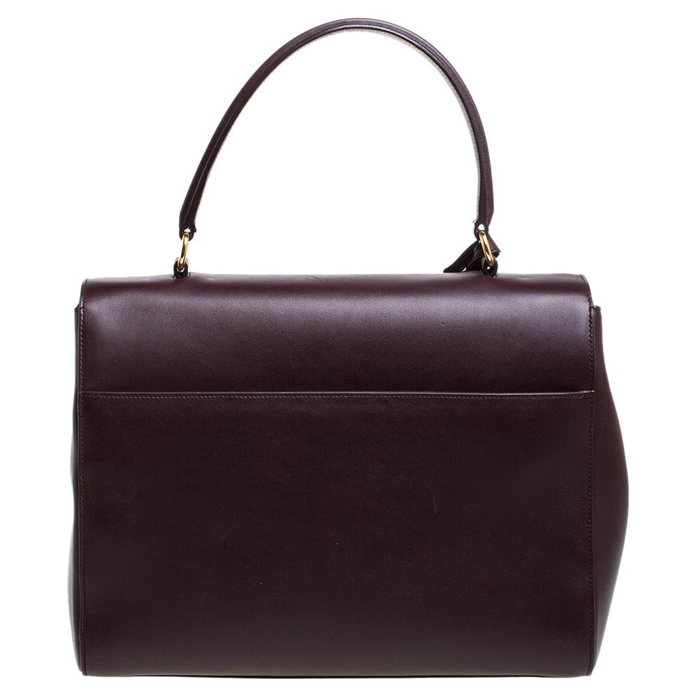 This stunning bag from Saint Laurent is a must-have. Crafted from leather, it comes in a burgundy color and delivers sophistication in spades. Its top handle can carry it to flaunt your fashion choices. The exterior features a gold-tone stamped logo
