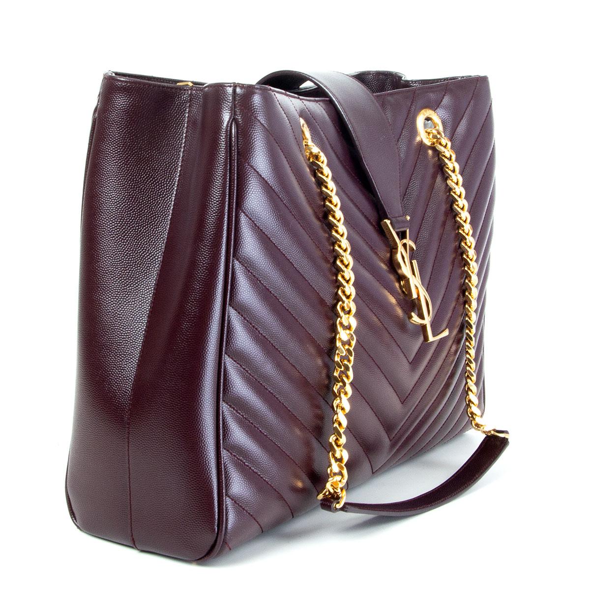 authentic Saint Laurent 'Monogram Shopping Large' tote in chevron quilted burgundy Grain de Poudre calfskin featuring gold-tone hardware. YSL buckle logo closure and has two metal chain-link and leather shoulder straps. The interior is lined in