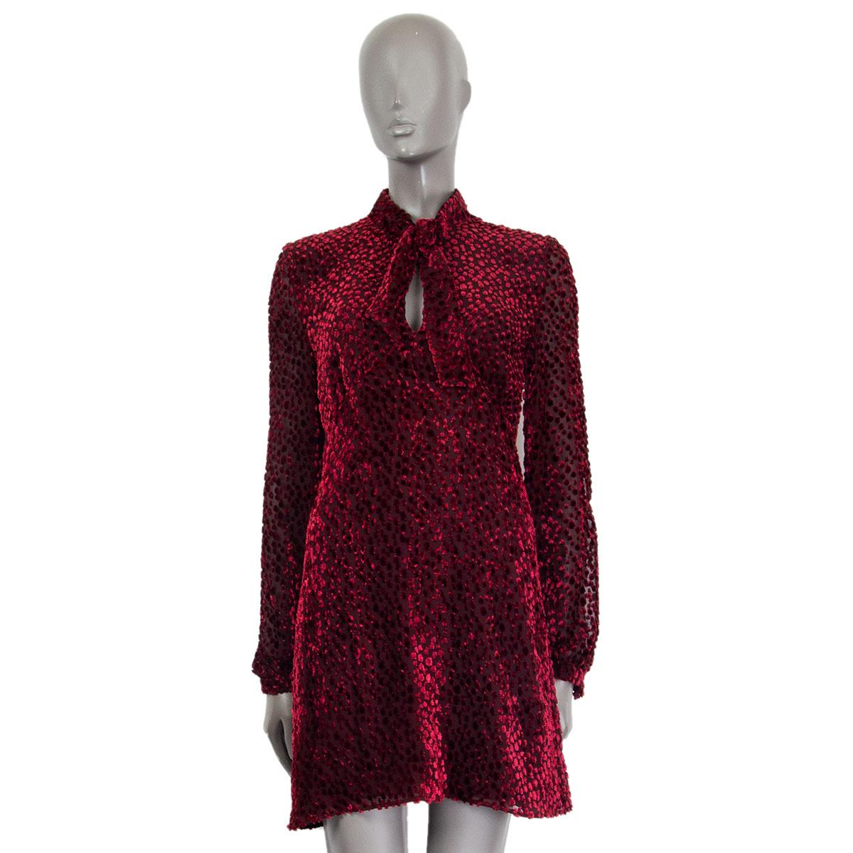 Saint Laurent pussy-bow devoré-chiffon mini dress in burgundy viscose (60%) and siilk (40%) with a lavallière-neck, long semi sheer sleeves and buttoned cuffs. Closes on the back with a concealed zipper. Lined in silk (100%). Has been worn and is in