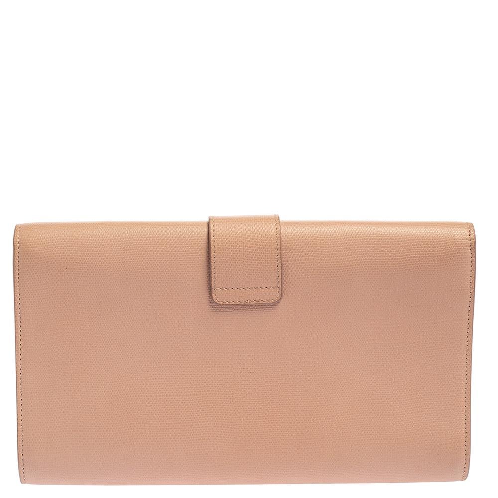 This clutch by Saint Laurent is a fine example of the brand’s stately minimalistic aesthetics. Crafted in leather, the clutch features the brand’s signature Y in gold-tone metal on the flap. The top magnet flap opens to a satin-lined interior with a