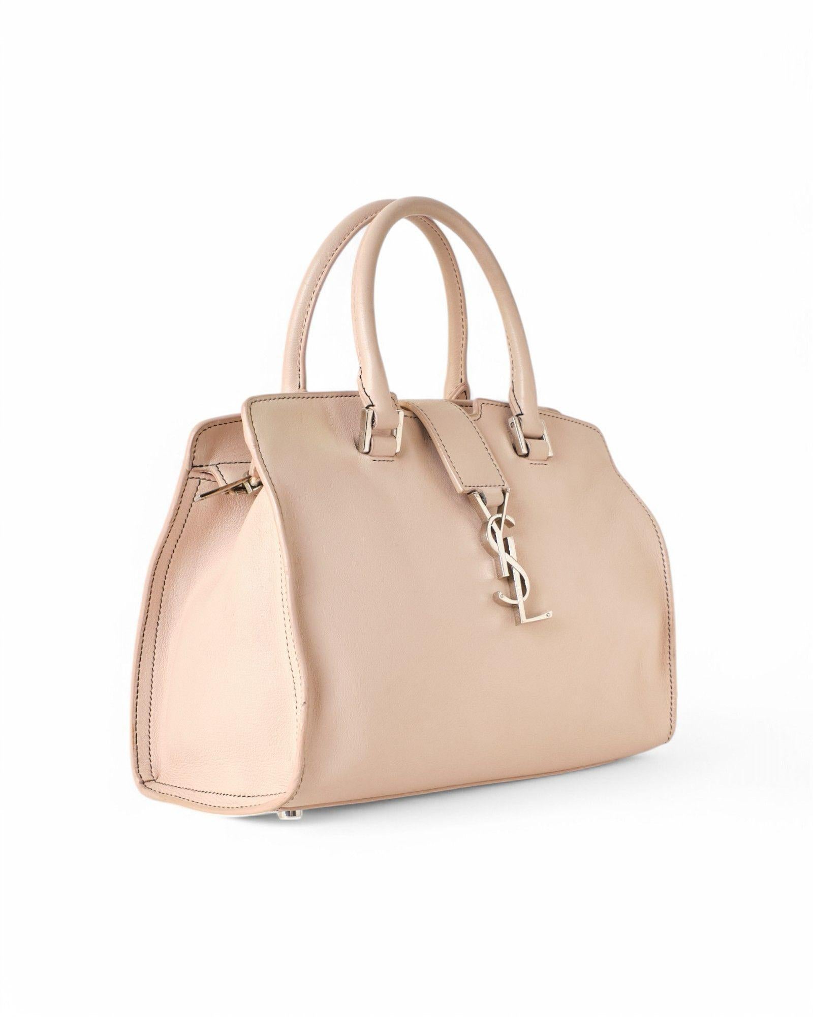 Saint Laurent signature bag, Cabas Baby model, made of leather  in the refined shade of powder pink  with silver hardware details. Featuring a double zipper closure and a central band with the classic silver metal 