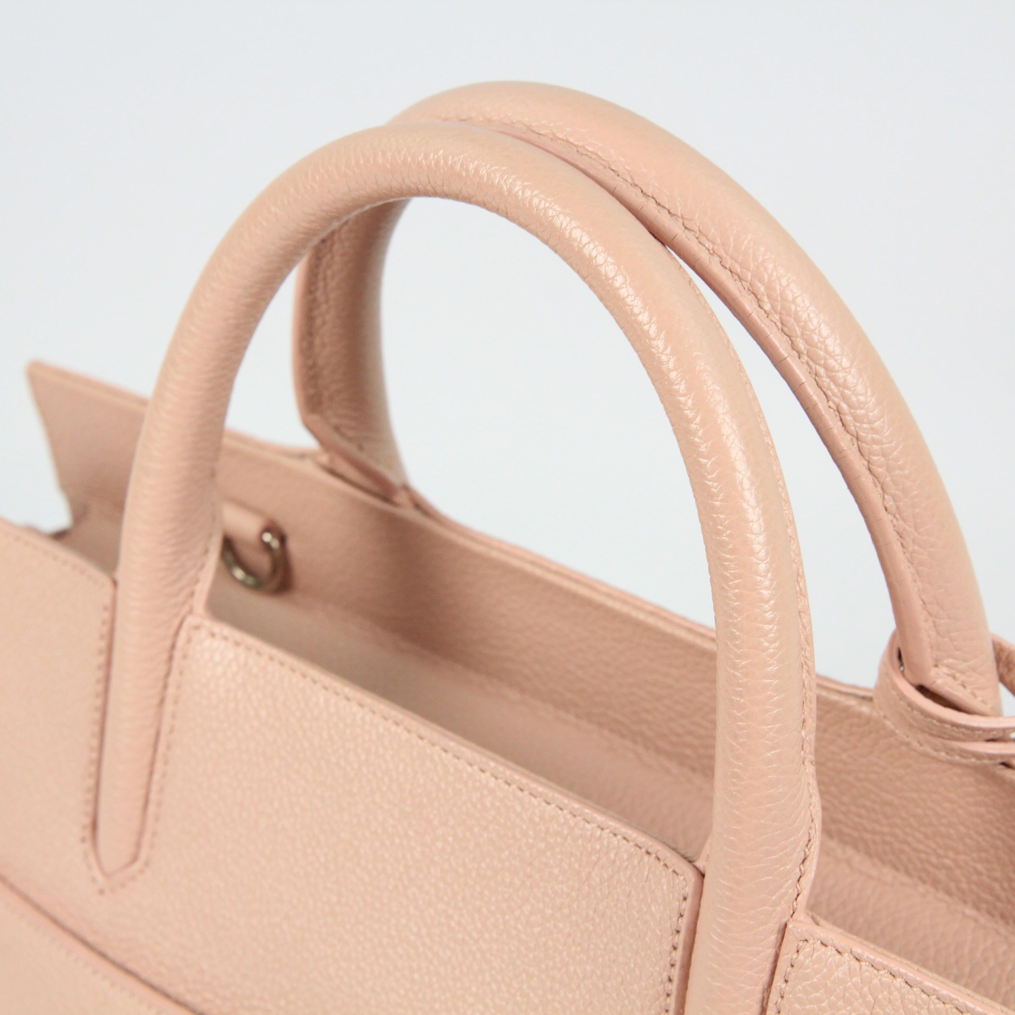 This is an authentic SAINT LAURENT Leather Cabas Rive Gauche in Beige Pink. This chic tote is crafted of calfskin leather in beige pink. The bag features rolled leather top handles and sewn anchors, button snap expandable side panels and a hanging